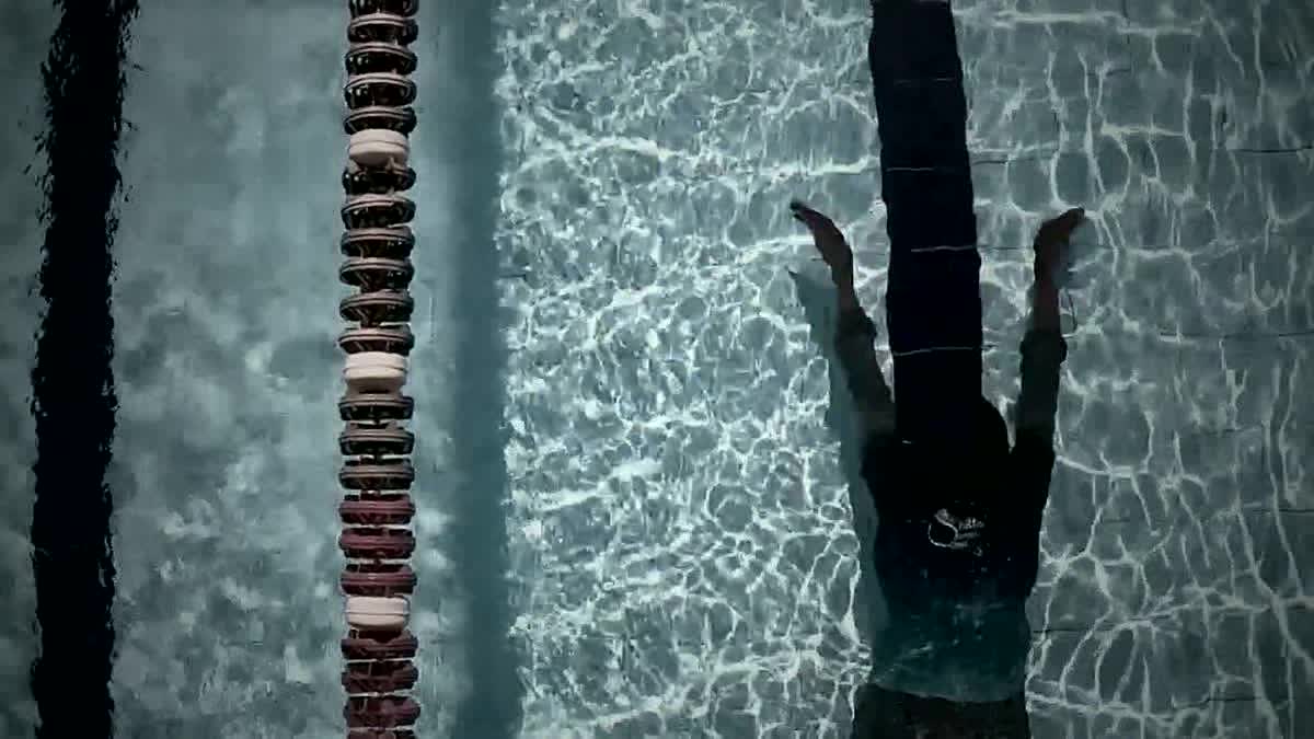 Underwater view of a swimmer mid-stroke, bubbles and motion